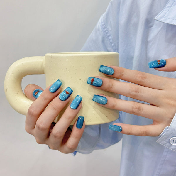Match Nails blue cat eye nails with a cup in hands