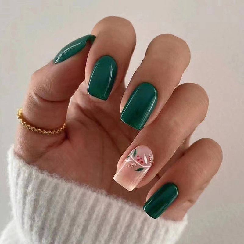 Mid-length green press-on nails featuring delicate floral decals and a glossy square shape for a charming spring manicure.